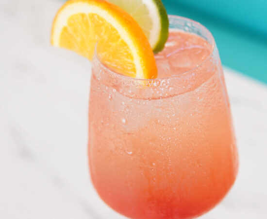Refreshing strawberry drink with lemon and lime garnish